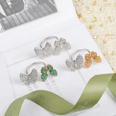 Silver rings with butterfly details on a ribbon backdrop